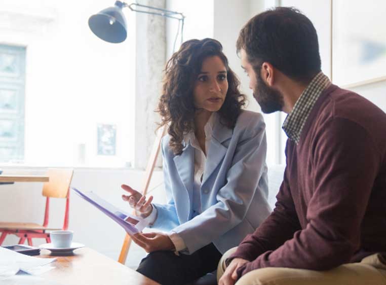 A woman consulting with a man at a desk